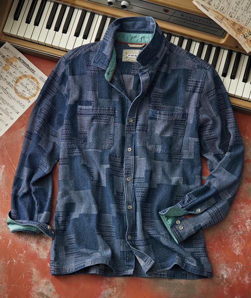 32 Bar Blues Cut Me In, a stylish patterned long-sleeve shirt with a green inner lining laid on a surface next to a piano and sheet music.