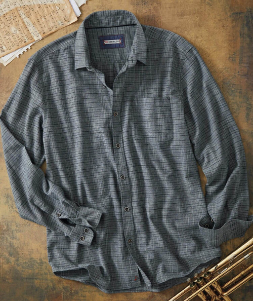 32 Bar Blues Sticks & Strings, a long-sleeve button-up shirt in gray with a checkered pattern, laying flat on a wooden surface with sheet music and a brass instrument nearby.