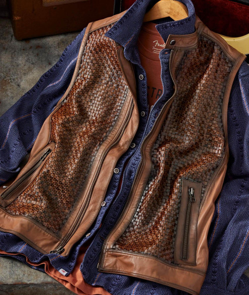 32 Bar Blues Hello Number One, stylish men's leather and fabric vest with woven leather panels and zippered pockets, layered over a denim shirt and T-shirt for a fashionable look.
