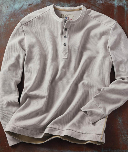 32 Bar Blues Bassism, a light grey long-sleeve shirt with a Henley neckline and button placket, laid flat on a rustic surface.