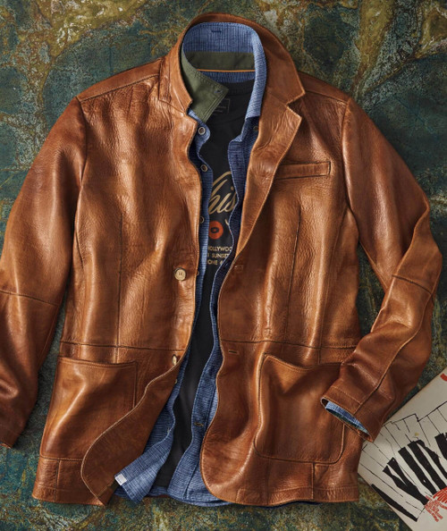 32 Bar Blues Flyjack, a stylish men's brown leather jacket layered over a blue shirt and black T-shirt, on a textured background.
