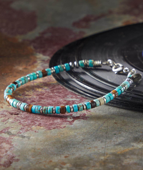 32 Bar Blues Boogie Blues, beaded necklace made of turquoise and brown beads with silver accents, displayed on a vintage record surface.