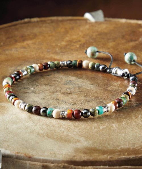 32 Bar Blues Status Flux, beaded beaded necklace with colorful beads including turquoise, coral, and silver, on a wooden surface.