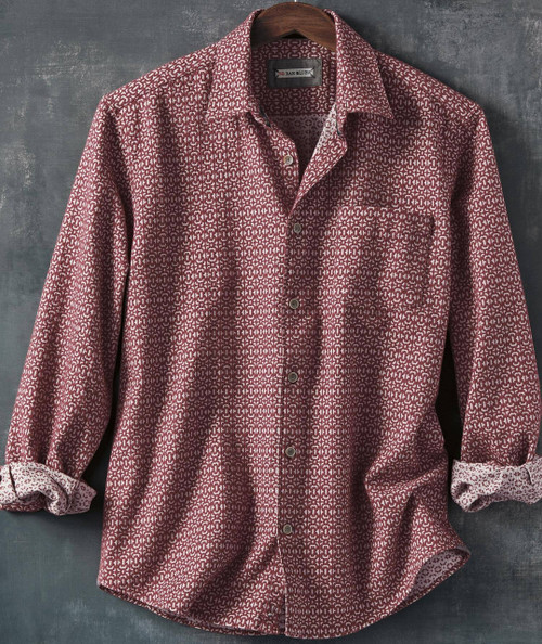 The Ace's Shuffle, long-sleeve button-up shirt with a red and white geometric pattern, displayed on a hanger against a dark background.