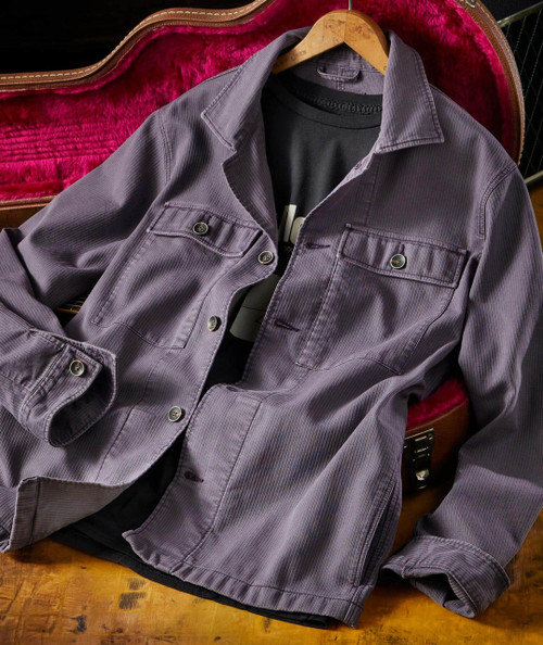 Are You Ready? jacket, purple corduroy denim jacket with front pockets and buttons, placed on a wooden surface with a black T-shirt underneath.