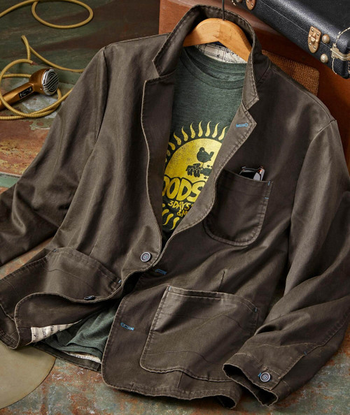 Better Ways, image of a casual men's outfit with a brown blazer, green graphic T-shirt, and accessories on a rustic surface.