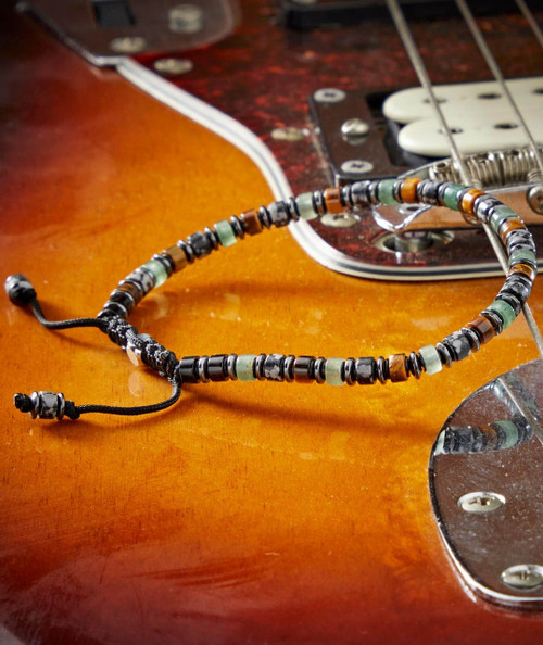 Jambalaya, close-up of an acoustic guitar with a beaded necklace resting on its body.