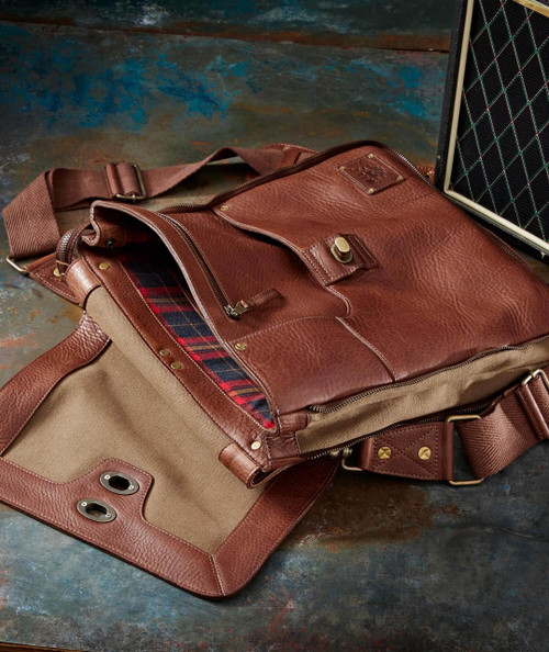 Where I Wander Leather and Canvas Duffel Bag, stylish brown leather and tan canvas travel bag with interior plaid lining and shoulder strap on dark surface