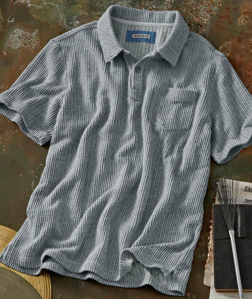 Spindrift, gray ribbed short sleeve shirt with chest pocket and button-up front lay on a rustic surface.