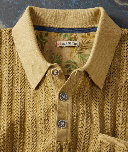 Change Directions, close-up of a mustard yellow cable-knit sweater with a collared neckline and three buttons.