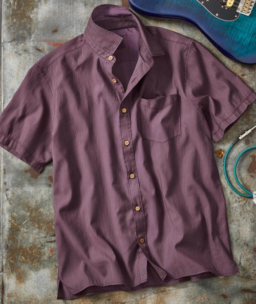 Twilight Time, purple short-sleeve button-up shirt with a pocket, laid flat on a textured surface next to a blue acoustic guitar and a turquoise cord.