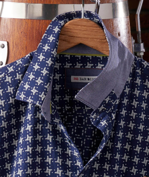 Got My Plans Squared Away, patterned blue shirt with white designs hanging on a wooden hanger.
