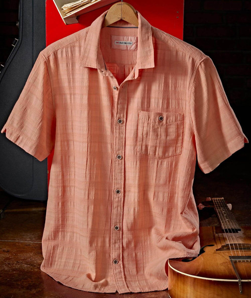 Side Effects, a pink short-sleeve button-up shirt hanging on a wooden hanger.