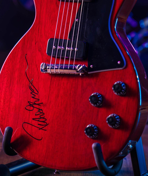 Autographed Peter Frampton Guitar, electric guitar with a red finish, black pickguard, and signature by Peter Frampton on the body.