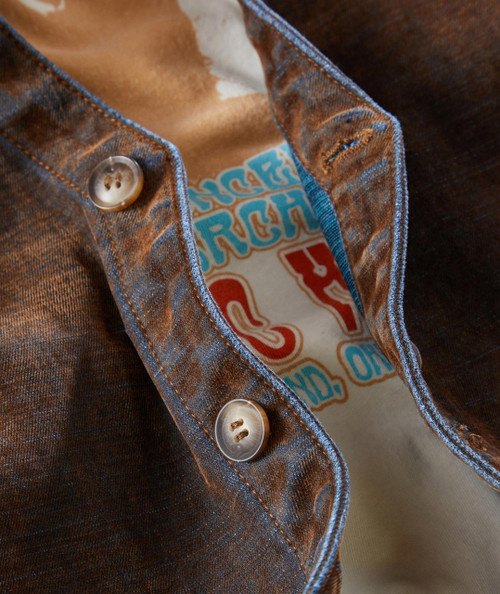 Rad Gumbo, close-up of the brown denim shirt with white buttons and blue stitching, showing the inner colorful text lining.