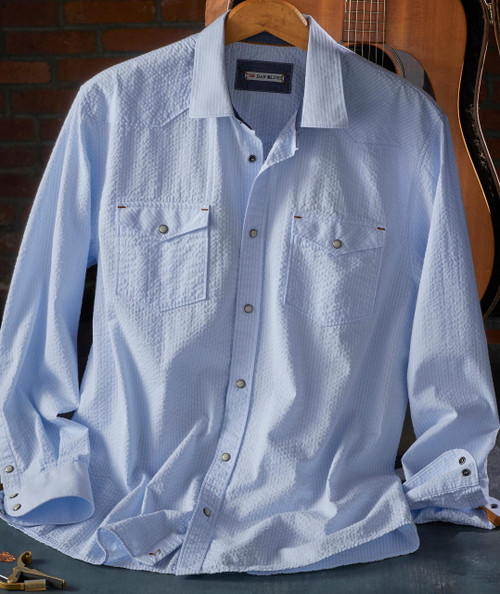 Take It To The Sky, white textured men's Western shirt with snap buttons and flap chest pockets, displayed on a hanger with a guitar in the background.