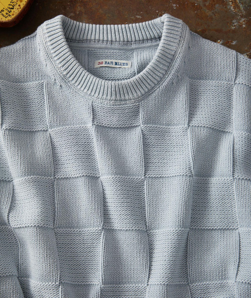 Block Rock, a knitted sweater with a checkered pattern of raised and flat squares in light grey color.