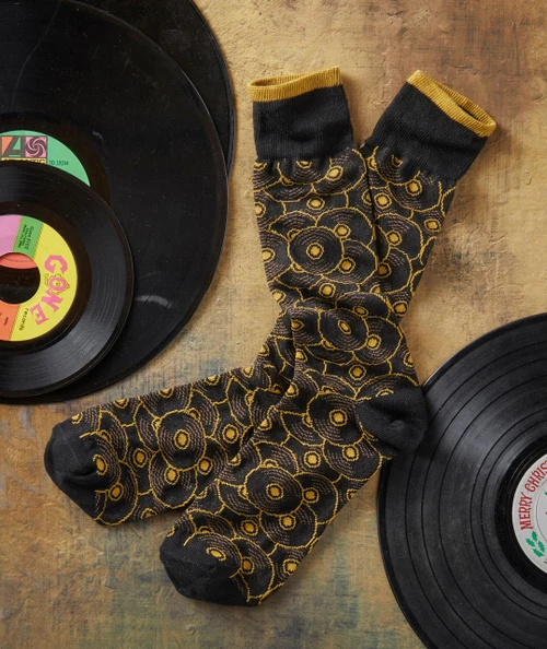 Put Your Records On, vintage vinyl records with colorful labels and a pair of black and yellow patterned socks.