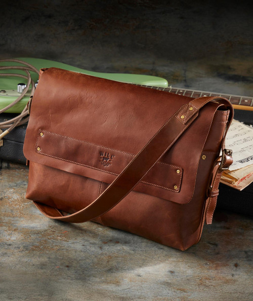 Somebody's Got To Go leather messenger bag, stylish brown leather bag with shoulder strap and front pocket, perfect for work or travel.