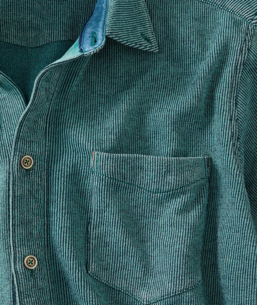 Blue In Green, close-up of a teal and navy striped denim shirt with a chest pocket and button closure.