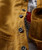 Product 32 Bar Blues Boss Jack, close-up of a mustard yellow textured shirt with four gray buttons.