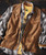 32 Bar Blues So Do It, clothing layered including a checkered shirt, a brown vest, and a yellow t-shirt, on a wooden surface.