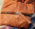 Product 32 Bar Blues Quicker The Better, a close-up image of a brown quilted leather jacket with a silver zipper.