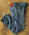 32 Bar Blues No Better Than This - Light Indigo, classic blue jeans with a leather patch on the waistband, laid flat on a textured, rusty surface.