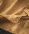 32 Bar Blues Honey In A Hurry, close-up image of a brown textured fabric with a small embroidered red musical note.