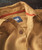 32 Bar Blues Honey In A Hurry, close-up of a mustard-colored patterned shirt with brown buttons and a blue label inside the collar.