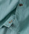 32 Bar Blues Ripple Shirt, close-up of a turquoise button-up shirt with vertical stripes and orange embroidered logo on the sleeve cuff.