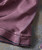 32 Bar Blues Who's Got Rhythm? , close-up image of a pinkish-brown fabric with visible stitching and seam details.