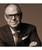 32 Bar Blues Bill Charlap - Street of Dreams, close-up portrait of jazz pianist Bill Charlap wearing glasses, a suit, and a tie, smiling confidently.