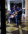 32 Bar Blues Jeff Fasano - Americana Portrait Sessions, a man playing an electric guitar while seated in a high-backed armchair in a luxurious indoor setting.