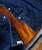 32 Bar Blues Vibrations In Blue, close-up of a denim quilted jacket with orange lining and snap buttons.