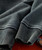 32 Bar Blues Just Live Your Life album, close-up of a dark-colored fabric jacket with ribbed cuffs and textured surface.