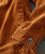 32 Bar Blues This Is The Place To Be, close-up of a rust-colored corduroy jacket sleeve with a button detail.