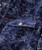32 Bar Blues Mr. Night Time, close-up of a denim jacket featuring a dark blue wash with speckled white patterns, contrast orange stitching, and a white button on the chest pocket.