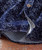 32 Bar Blues Mr. Night Time, close-up of a dark blue velvet jacket with a textured pattern, featuring a button and orange stitching details.