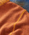 32 Bar Blues Good Old Cider, close-up of a reddish-orange textured fabric with yellow stitching.