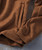 32 Bar Blues Over Easy, close-up image of a brown hoodie featuring a front pocket and ribbed cuffs in a casual style.