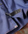32 Bar Blues Blue Mountain Hop, close-up of a blue patterned shirt with orange stitching and a black inner lining on the collar.