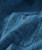 Broken Shadows, close-up image of blue patterned fabric with a button detail.