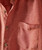 Inside Track, close-up image of a red patterned shirt with a chest pocket and brown buttons.