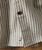 Straight Up And Down Men Shirt, Close-up of beige men's striped shirt with black and white vertical lines, button detail, and embroidered logo.