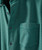Bluegrass Break Up, close-up image of a textured teal jacket with buttons and a pocket.