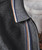 Better Than Yesterday, close-up of a grey zip-up hoodie with colorful striped detailing, worn over a white graphic t-shirt.