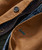 Better Ways, close-up of a brown and blue jacket showing button and pocket details.