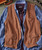 Hip Pockets, a brown vest with two front flap pockets with buttons, layered over a blue striped shirt with additional hip pockets.