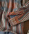 Brilliant Corners, close-up of a colorful, striped patterned shirt showcasing the fabric texture and button details.